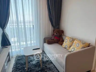 Cozy living room with plush sofa, teddy bear, and natural light