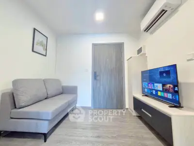 Modern living room with sleek furniture and wall-mounted TV in a stylish apartment.