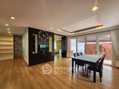 Spacious modern living room with dining area and stylish wall clock