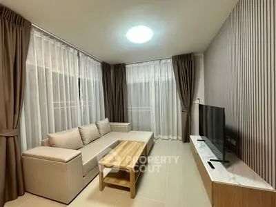 Modern living room with sleek furniture and floor-to-ceiling windows