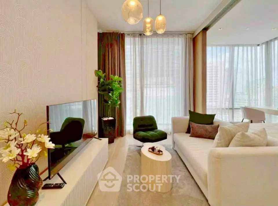 Elegant living room with modern decor, large windows, and cozy seating area.