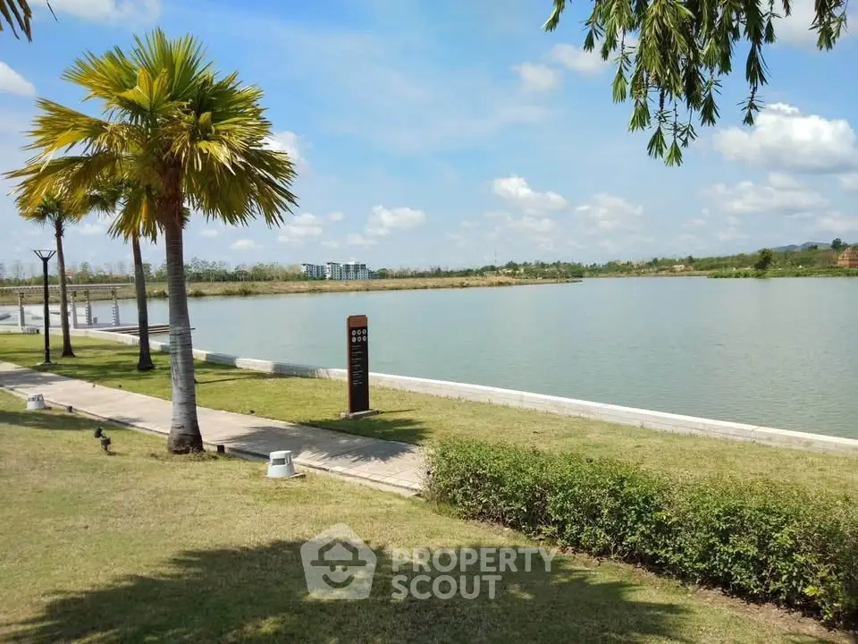 Scenic lakeside view with lush greenery and clear blue sky, perfect for serene living.