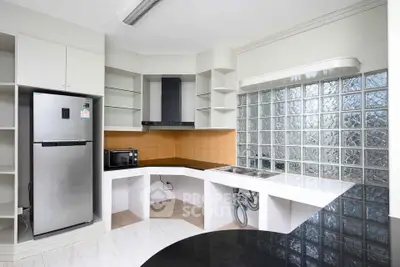 Modern kitchen with sleek appliances and unique glass block wall design.