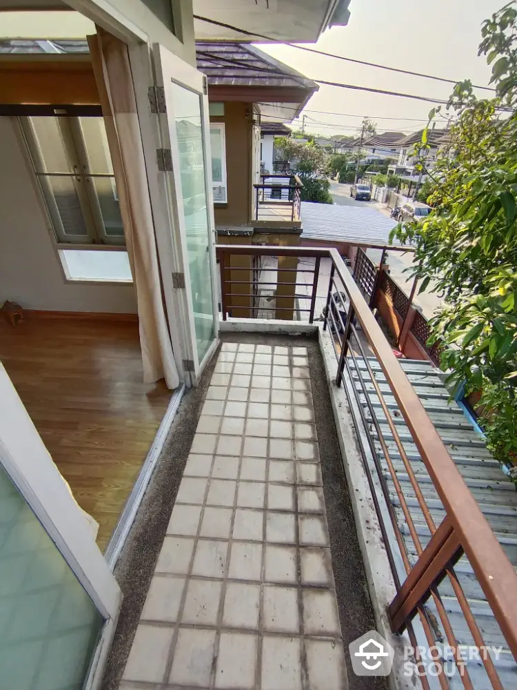 Charming townhouse balcony with a serene suburban view, offering a peaceful outdoor retreat adjacent to a cozy interior space with ample natural light.