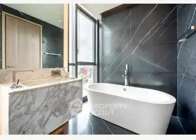 Luxurious bathroom with freestanding tub and marble accents in modern apartment