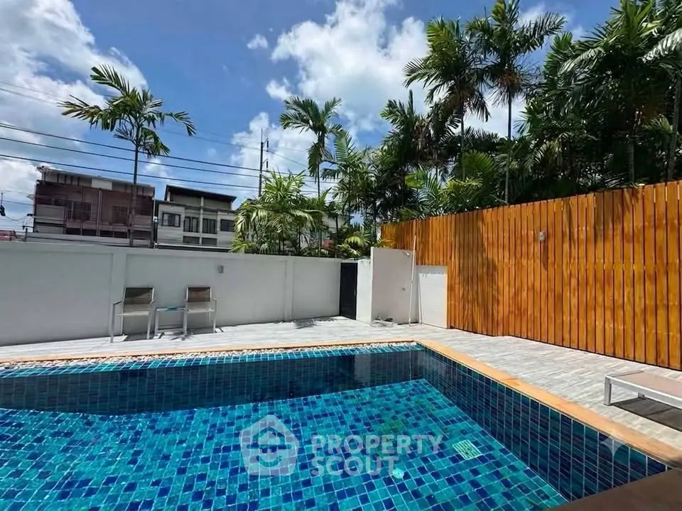 Luxurious private pool with tropical landscaping and modern fencing, perfect for relaxation and entertainment.