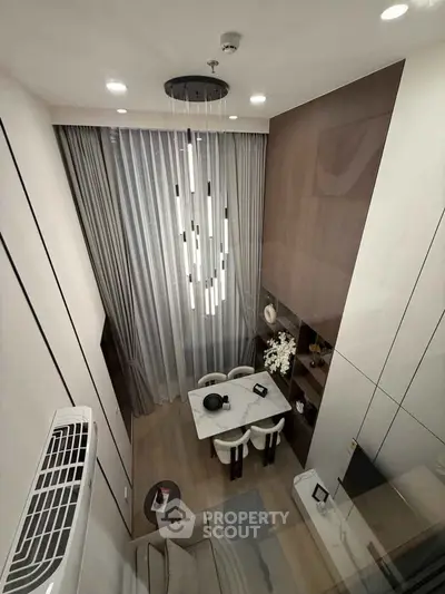 Luxurious modern living room with high ceiling and elegant chandelier in a stylish apartment.