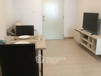 Cozy living room with dining area and modern TV setup in a compact apartment.