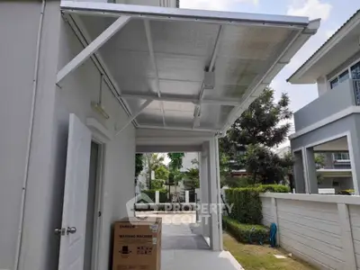Modern house exterior with covered patio and Samsung washing machine box