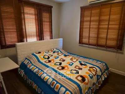 Cozy bedroom with wooden blinds and colorful bedding, perfect for a restful retreat.