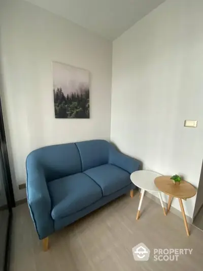 Cozy small living room with blue sofa and modern decor