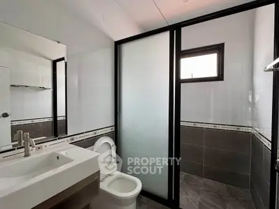 Modern bathroom with sleek design featuring a glass shower enclosure and contemporary fixtures.