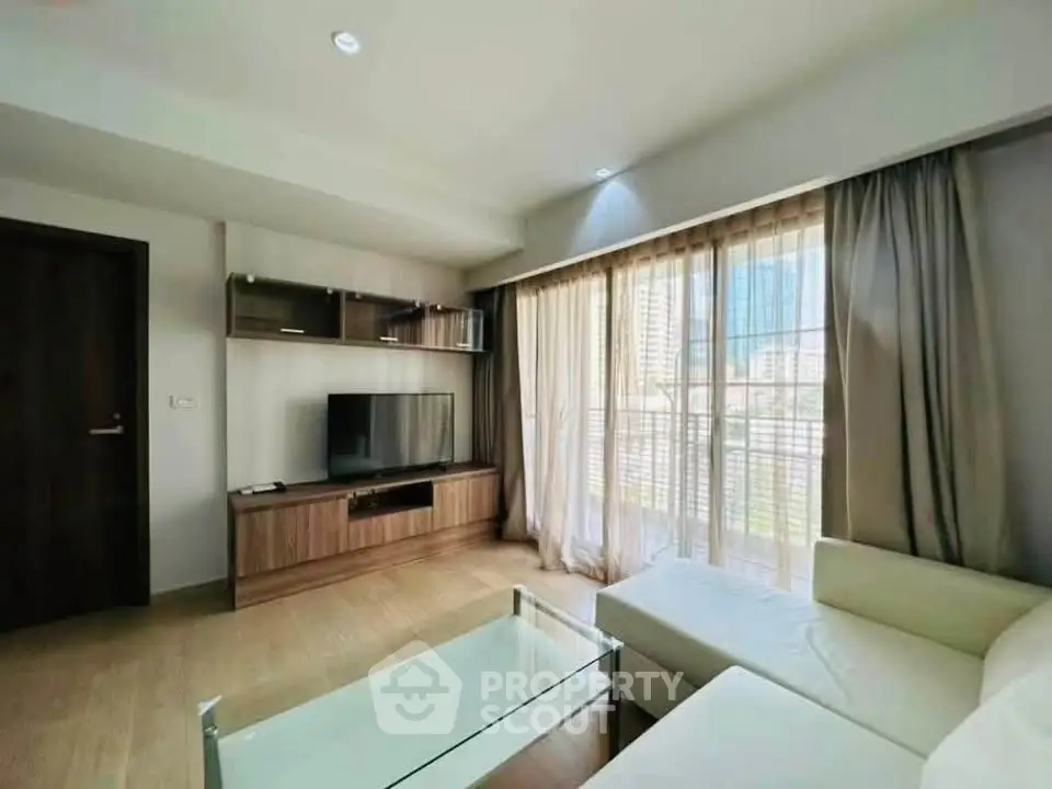 Modern living room with large window and stylish furniture in a high-rise apartment.