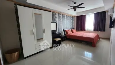 Spacious modern bedroom with stylish decor and ample natural light.