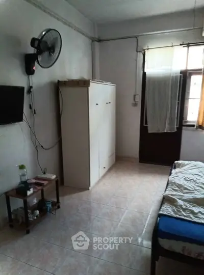 Cozy bedroom with natural light, wall-mounted fan, and minimalist decor.