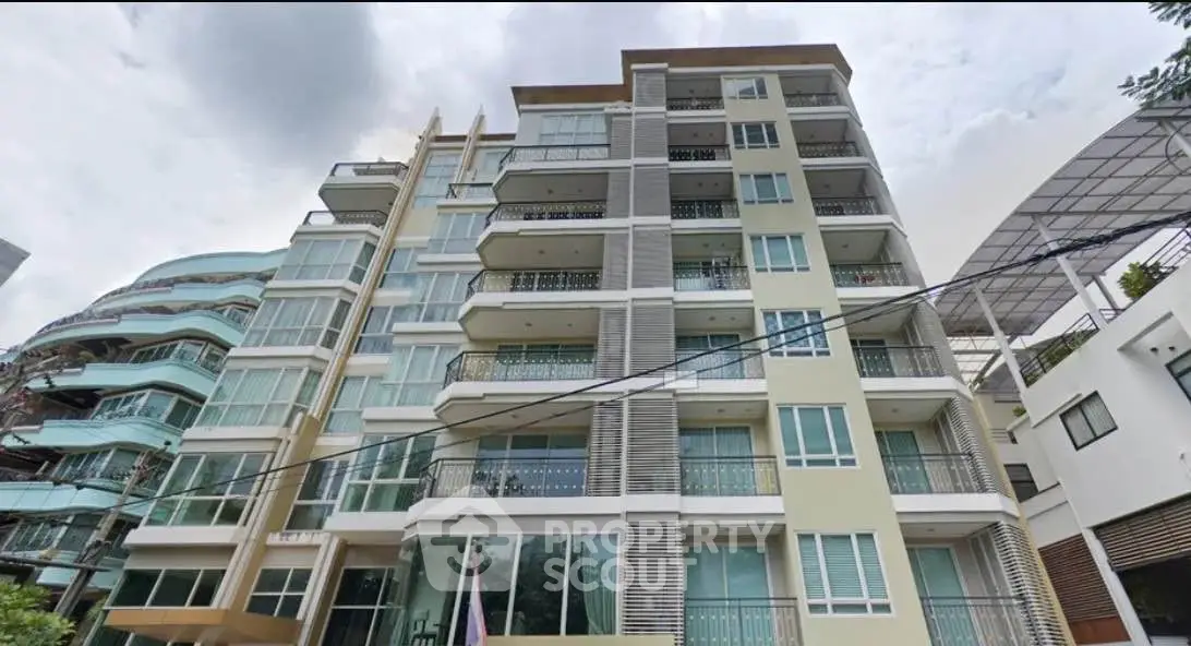 Modern multi-story residential building with balconies and large windows
