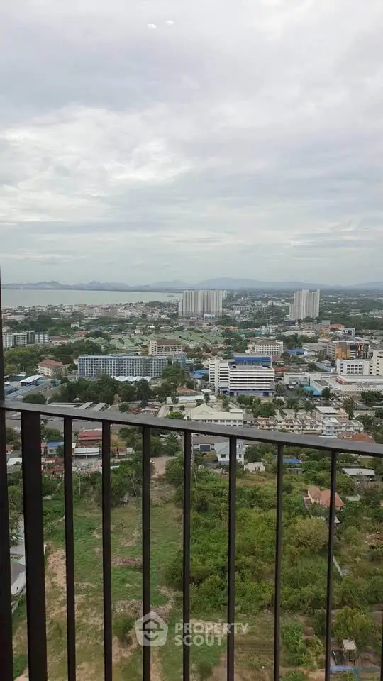 Stunning cityscape view from high-rise balcony with expansive skyline and lush greenery.