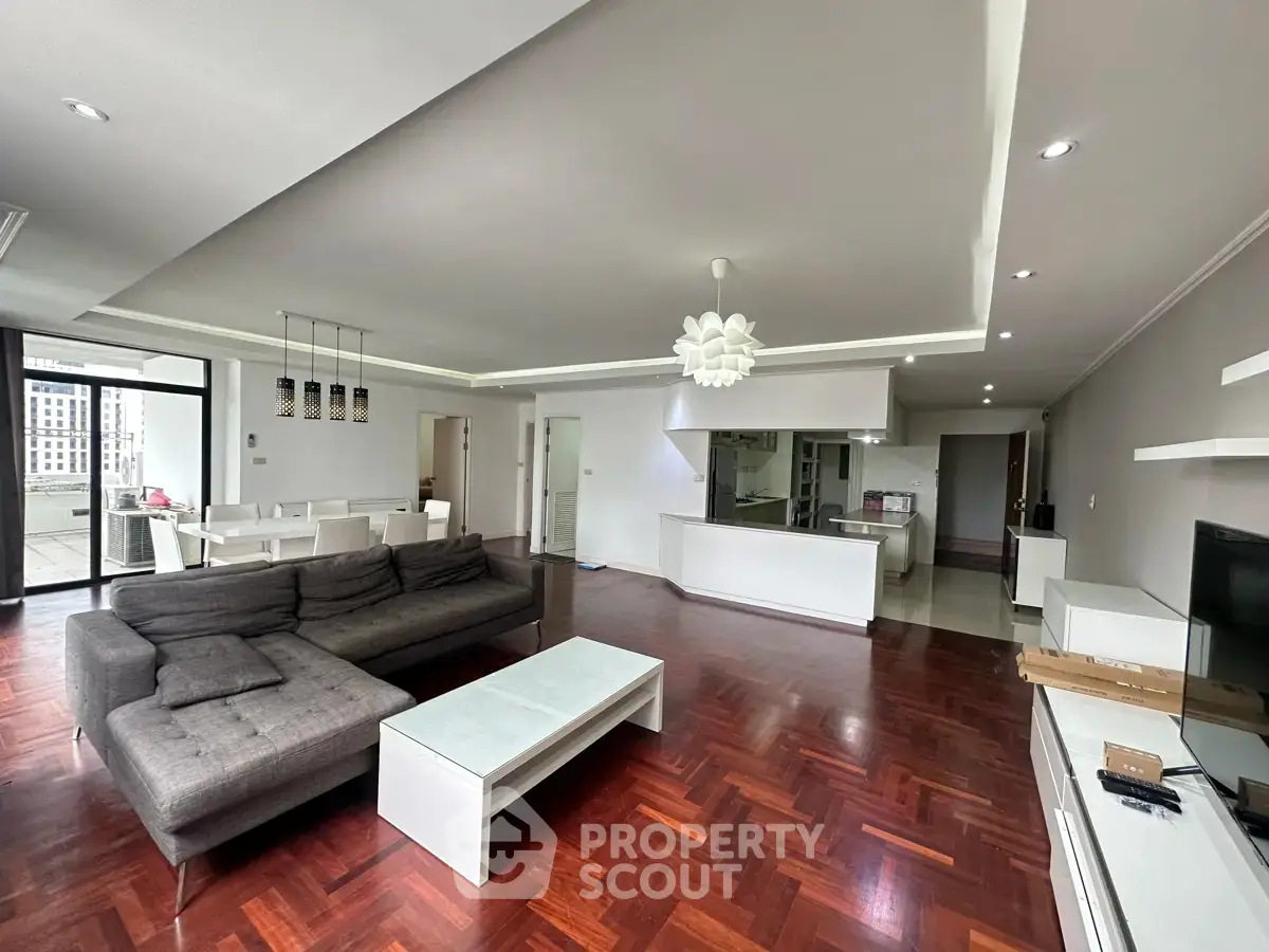 Spacious modern living room with open kitchen and elegant hardwood floors