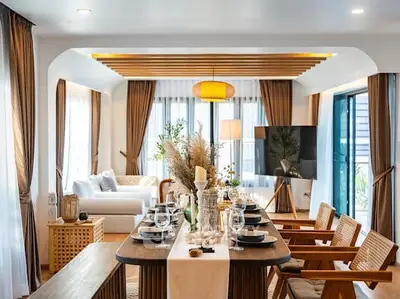 Elegant living room with dining area, featuring modern decor and large windows for natural light.