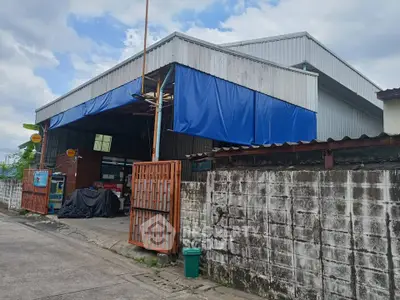 Spacious industrial warehouse with secure gated entrance and ample outdoor space.
