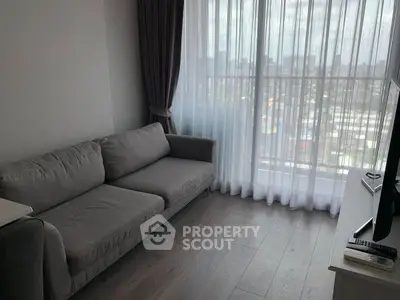 Modern living room with gray sofa and city view through large window