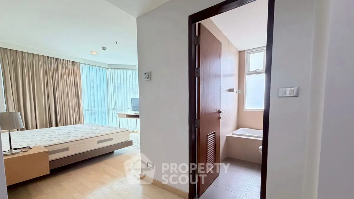 Spacious bedroom with ensuite bathroom in modern apartment