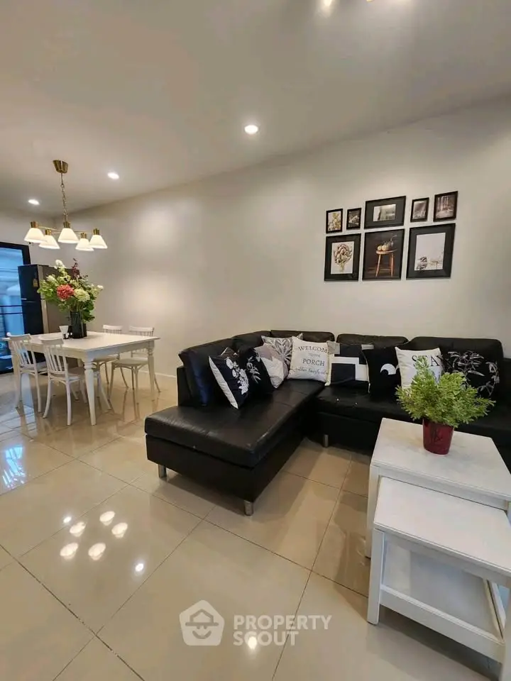 Modern living room with stylish black leather sofa and elegant dining area