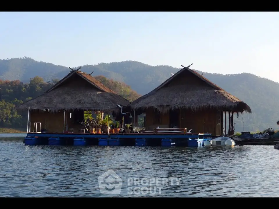 Charming floating huts on serene lake with mountain backdrop, perfect for tranquil living.