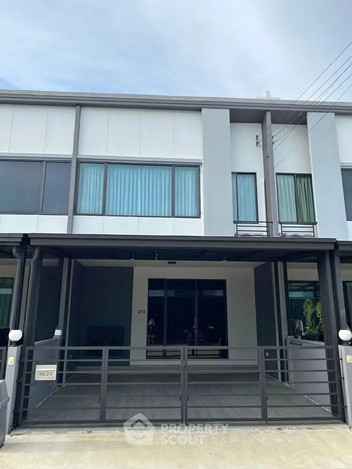 Modern townhouse exterior with sleek design and spacious driveway, perfect for urban living.
