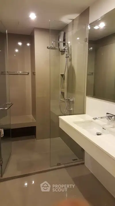 Modern bathroom with glass shower enclosure and sleek fixtures