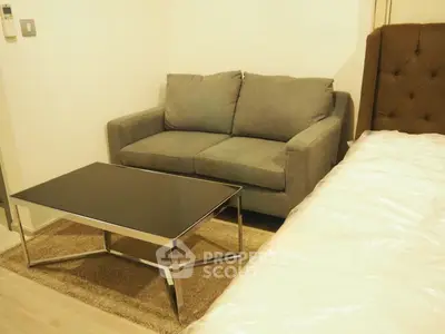 Cozy bedroom with modern sofa and sleek coffee table, perfect for relaxation and comfort.