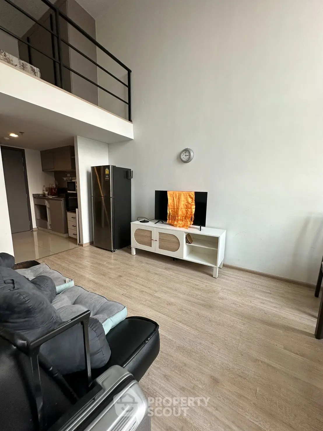 Modern living room with loft, sleek furniture, and open kitchen layout in stylish apartment.