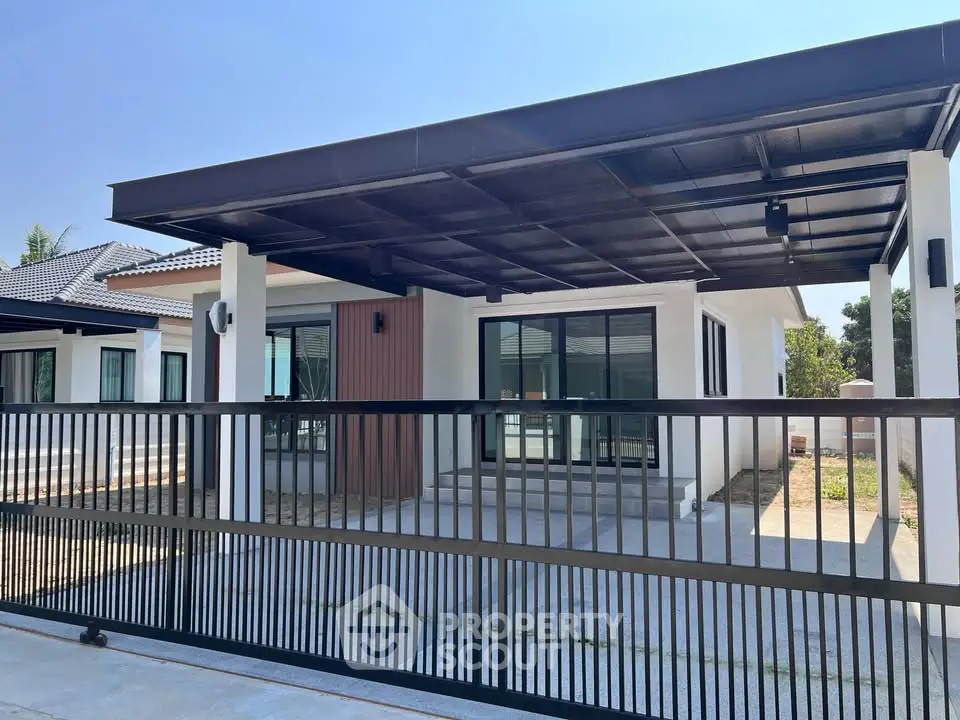 Modern single-story house with sleek design and spacious carport in a serene neighborhood.
