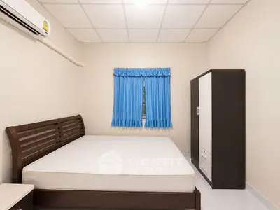 Cozy bedroom with minimalist design featuring a comfortable bed, wardrobe, and air conditioning.