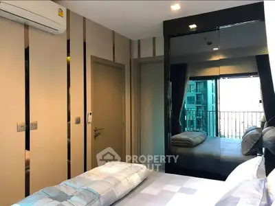 Modern bedroom with mirrored wardrobe and balcony view in a stylish apartment.