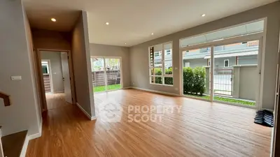 Spacious modern living room with large windows and wooden flooring