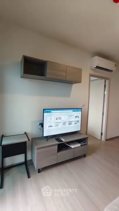 Modern living room with sleek furniture and wall-mounted TV in a stylish apartment.
