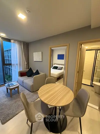 Modern apartment interior with cozy living room, dining area, and bedroom view, featuring stylish decor and natural light.