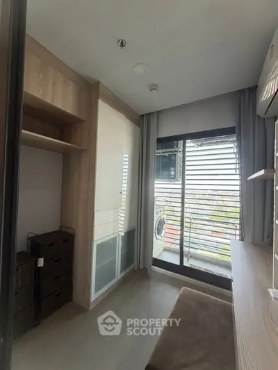 Modern compact room with balcony view and built-in storage, ideal for urban living.