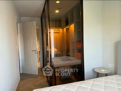 Modern bedroom with glass-enclosed walk-in closet and stylish decor