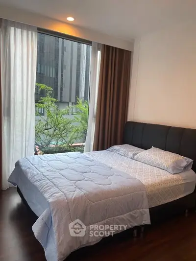Cozy bedroom with large window and modern decor in urban apartment