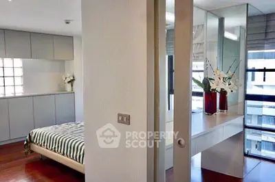Modern bedroom with stylish decor and large windows offering natural light.