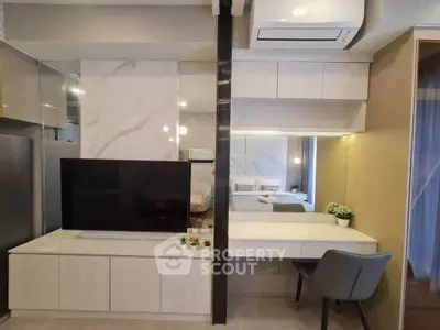 Modern living room with sleek TV unit and stylish decor, featuring a cozy workspace and air conditioning.