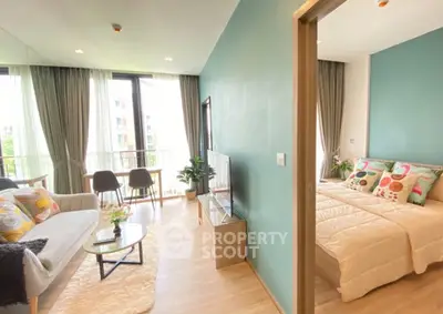 Modern apartment with cozy living room and bedroom, featuring large windows and stylish decor.