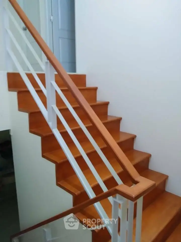 Elegant wooden staircase with sleek white railings in modern home interior