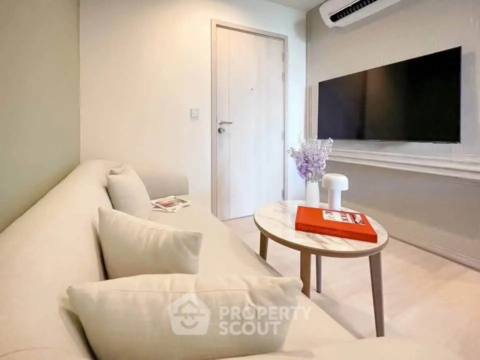 Modern living room with sleek TV setup and cozy beige sofa, perfect for relaxation.