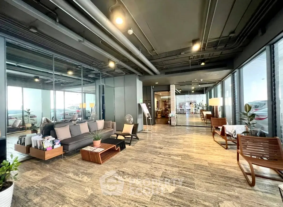 Modern lobby with stylish seating and floor-to-ceiling windows in a contemporary building.