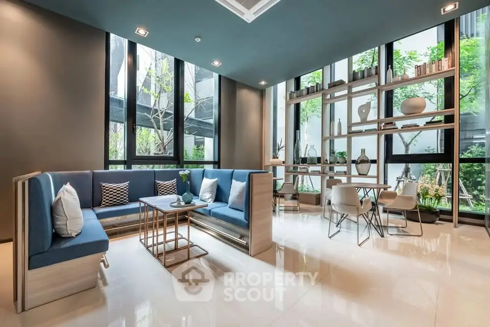 Modern living room with stylish furniture and large windows offering garden views.