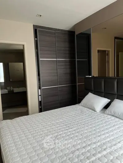 Modern bedroom with sleek wardrobe and comfortable bedding in a stylish apartment.
