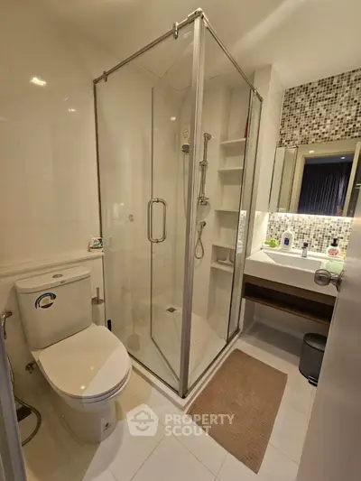 Modern bathroom with glass shower and stylish mosaic tiles
